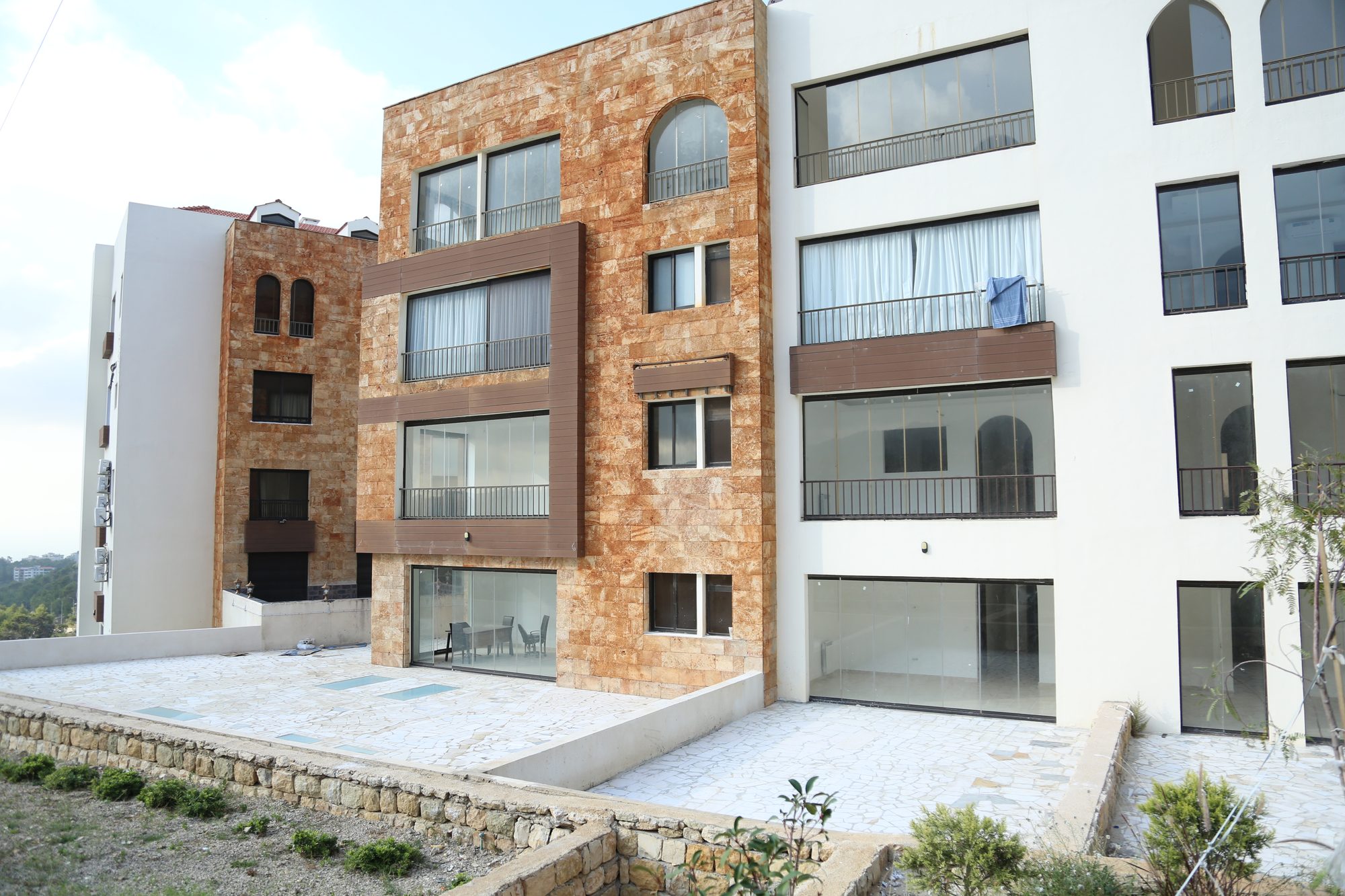 Three residential blocks with stone towers and shared terraces