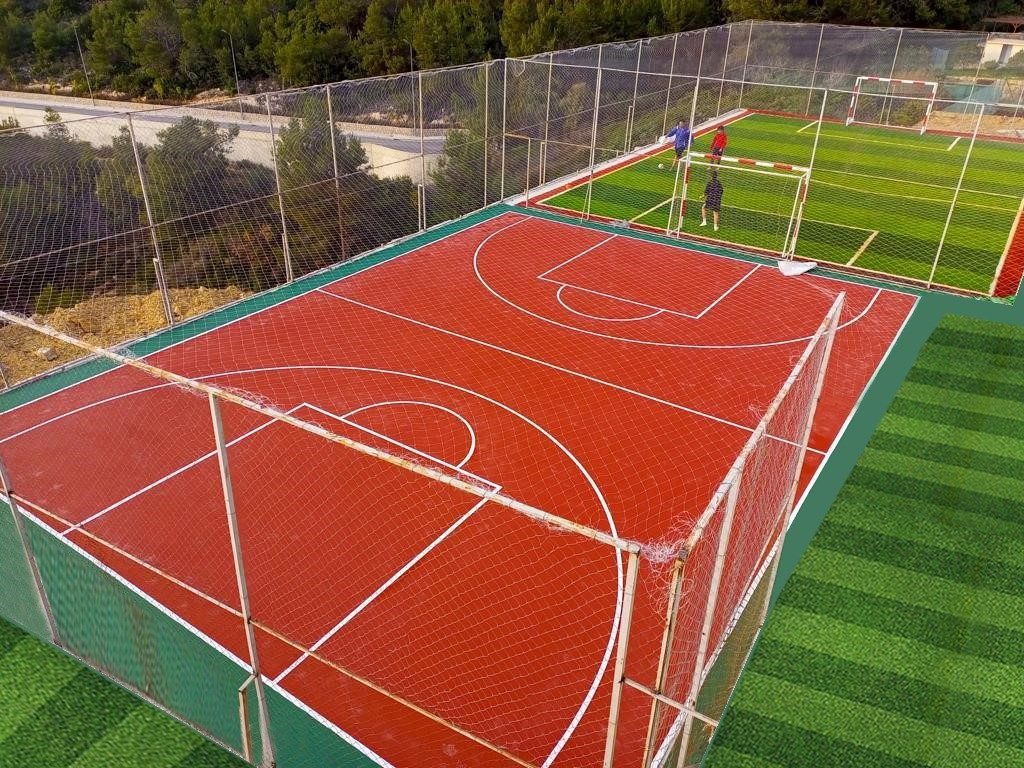The fenced basketball court and mini football pitch