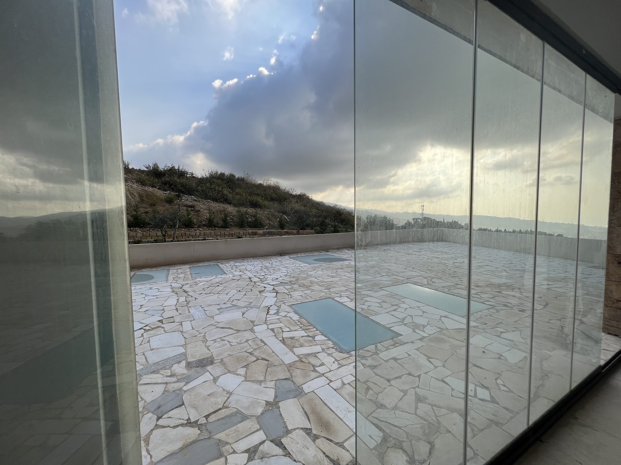 Full-height sliding glass opening onto the stone terrace