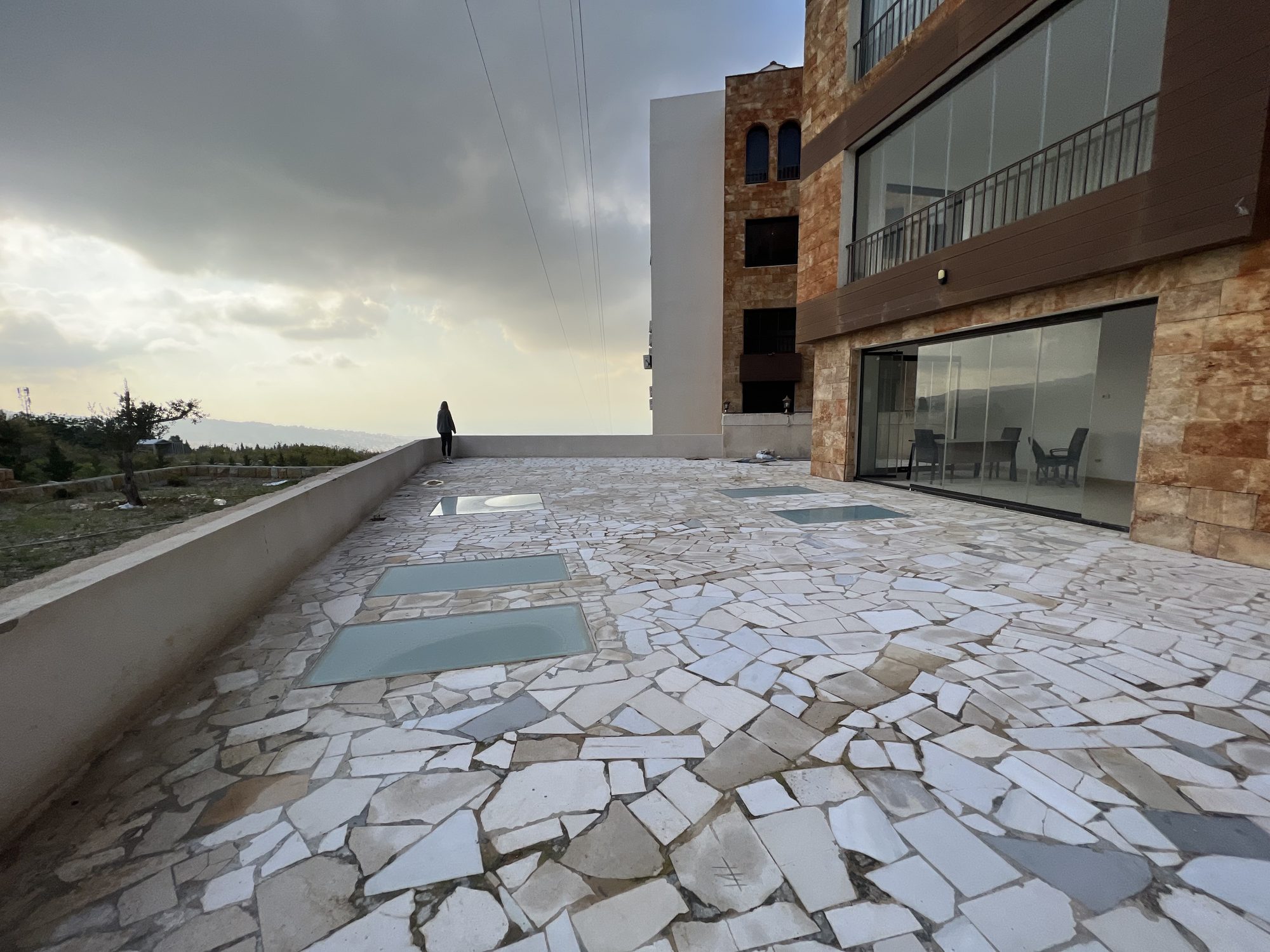 Wide stone-paved private terrace looking over the hills