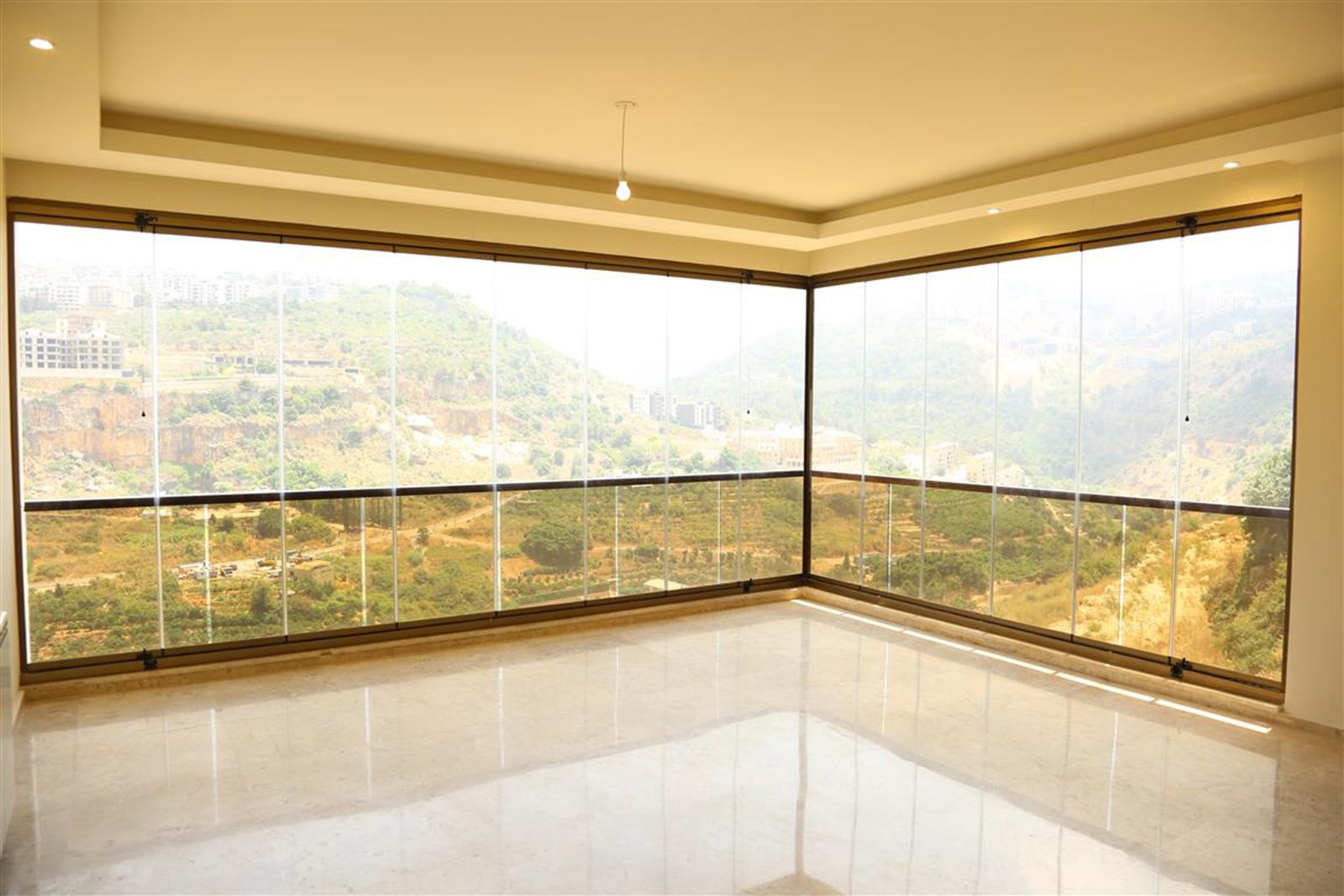 Corner living space with full-height sliding glass over the valley