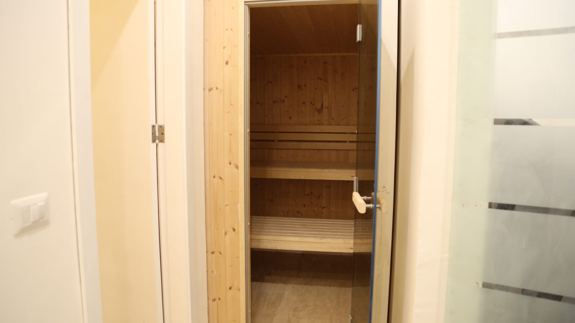 The wooden sauna behind its glass door